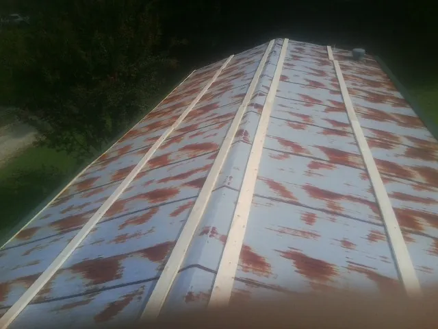 Rusted metal roof panels with new wood purlins before replacement — Storm Damage Roof Repair in Harper Woods by Roofing Brothers