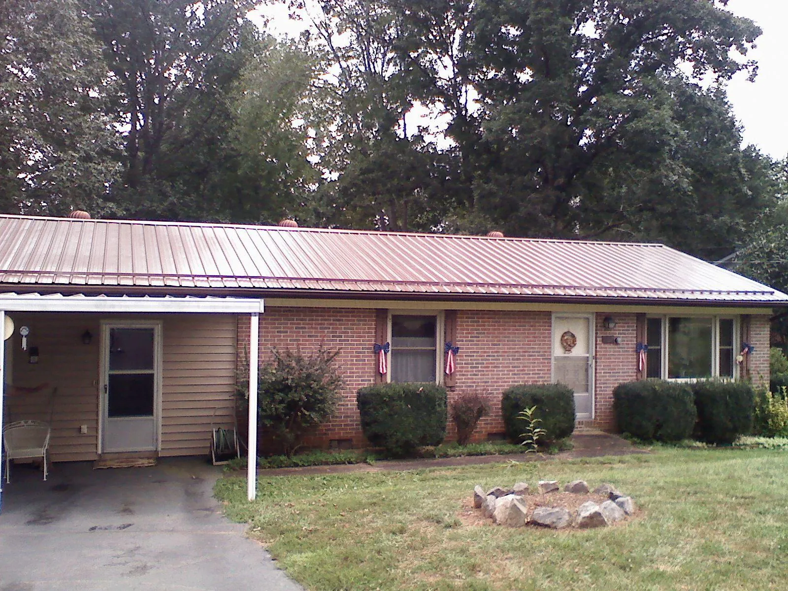 Bronze metal roof and carport on a brick ranch home — Roof Repair work by our crew in Harper Woods