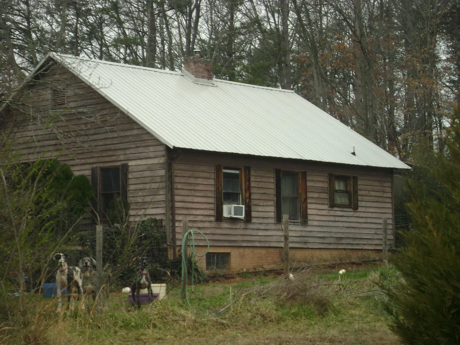 White metal roof on an old wood sided farmhouse, from a Metal Roof Installation job in Harper Woods